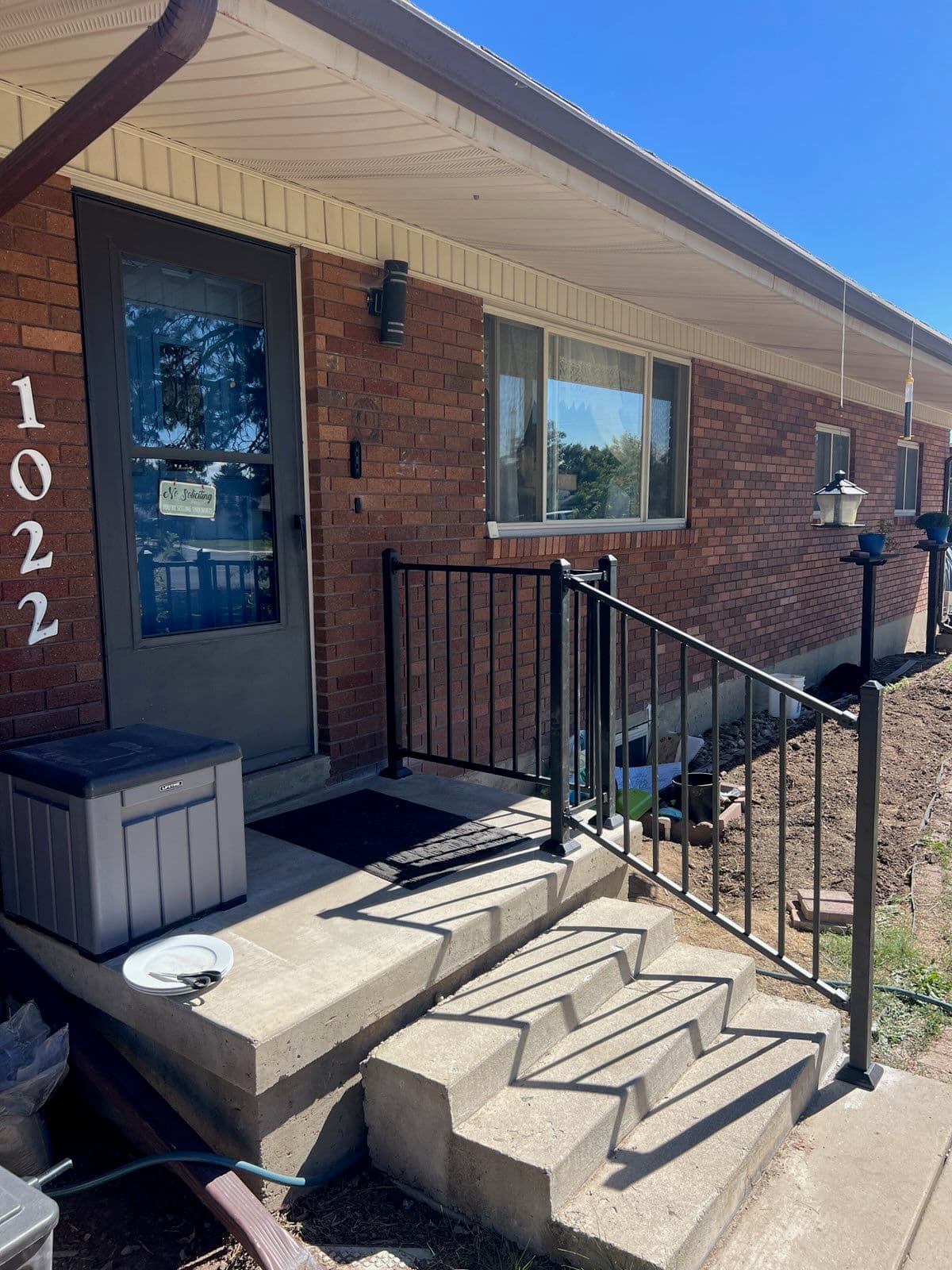 Stylish Black Metal Railing Installation Adds Safety and Elegance to Brick House Entrance image